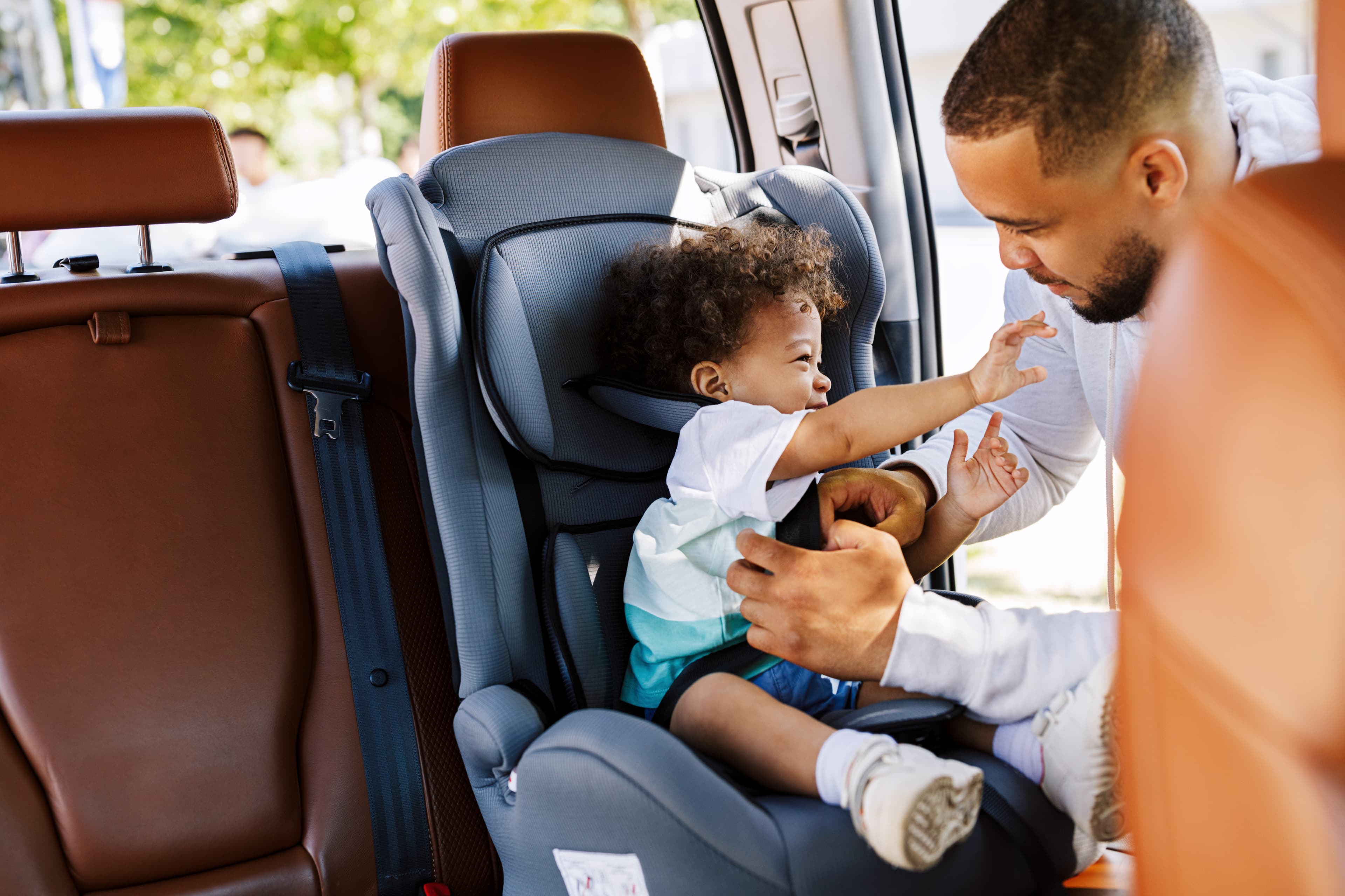Parent securing a child in a car seat